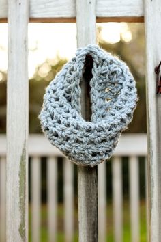 a crocheted wreath hanging on a wooden fence