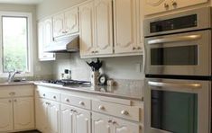 a kitchen with white cabinets and stainless steel appliances