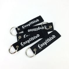 three black key chains with white writing on them