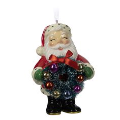 a glass ornament with a santa holding a wreath