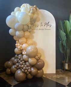 balloons are stacked on top of each other in front of a sign that says it's to mrs