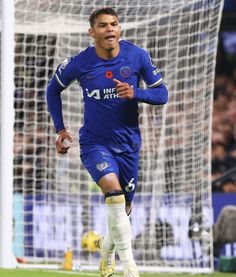 a soccer player running towards the goal with his mouth open and one foot in the air