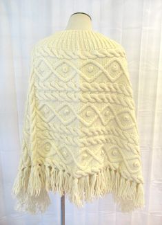 Cool vintage poncho of cream colored wool or wool blend. Pullover. One size fits all. Cute popcorn like balls throughout. Boat neck. Bust is 56 inches 25 inches long to bottom of the fringe. Notice how the outer edges hangs longer. No labels. More than likely hand made. Wonderful condition. Mannequin measurements are: 34 / 24-1/4 / 34-1/2 inches. Cozy Beige Wool Poncho, Beige Wool Poncho One Size, One Size Beige Wool Poncho, Hand-knitted Beige Poncho For Winter, Cream Knitted Poncho For Fall, Hand Knitted Beige Poncho For Winter, Hand Knitted Beige Poncho For Fall, Winter Cream Knit Poncho, Hand Knitted White Poncho For Winter