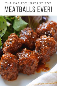 meatballs covered in sauce and garnished with parsley on a white plate