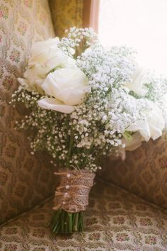 a bouquet of white flowers sitting on top of a couch