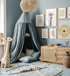 a child's bedroom with blue walls and pictures on the wall