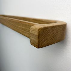 a close up of a wooden shelf on a wall with white walls in the background