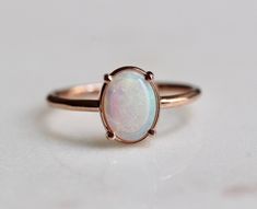 This Ring is a beauty! Each opal is unique picking up tones of blue, green, purple and pink. If you would like to choose your opal, please contact us after ordering and we will send over stone option. -Australian opal measures 8mm by 6mm -Oval Stone is held in place by a 4 prong setting -Round band measures 1.3 mm -Handcrafted out of 14K yellow, rose or white gold Processing times - Current processing time is 2 - 4 weeks. Each Item is handmade to order with love and care! In Stock Items - Contac Oval Pink Opal Gemstone Rings, Rose Gold Oval Opal Gemstone Ring, Oval Rose Gold Opal Gemstone Ring, Rose Gold Oval Opal Ring, Oval Opal Fine Jewelry Ring, Oval Rose Gold Opal Ring Gift, Elegant Oval Pink Opal Ring, Anniversary Pink Opal Oval Ring, Iridescent Oval Cabochon Ring