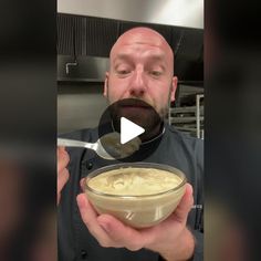 a man holding a bowl of food in front of his face and looking at the camera