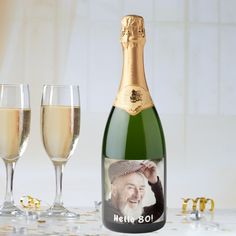 a bottle of champagne next to two wine glasses