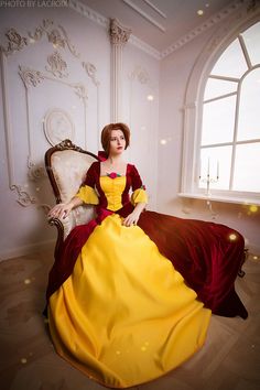 a woman in a yellow and red dress sitting on a chair