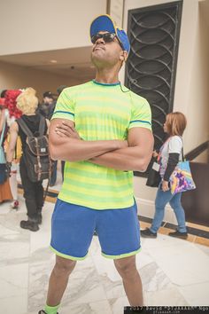 a man with his arms crossed standing in front of a group of mannequins