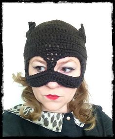 a woman wearing a crocheted cat mask with horns on her face and nose