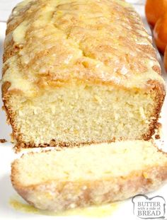 a loaf of bread sitting on top of a white plate next to some oranges