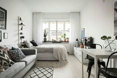 a living room filled with furniture next to a white table and chair in front of a window