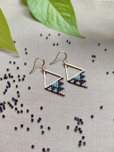 Embrace the allure of tribal artistry with our 'Spirit Triangle Earrings.' Each earring weaves a captivating Native American-inspired pattern in hues of beige, black, and turquoise blue. The subdued elegance meets vibrant energy, creating a harmonious balance.  Adorn yourself with these geometric treasures, where the Spirit Triangle Earrings embody the essence of tribal chic, adding a touch of bold style to your look. Handcrafted with love & precision, utilizing the ancient technique of bead wea Bohemian Triangle Adjustable Earrings, Bohemian Adjustable Triangle Earrings, Adjustable Bohemian Triangle Earrings, Triangle Beaded Earrings For Gifts, Beaded Triangle Earrings For Gifts, Bohemian Triangle Earrings With Ear Wire, Handmade Triangle Bohemian Jewelry, Handmade Bohemian Triangle Jewelry, Handmade Triangle Earrings For Festival