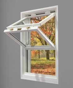 an open window with fall leaves outside it and trees in the backgrounge