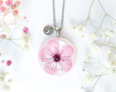 You certainly know that no two flowers are alike. Therefore, this custom cherry blossom necklace is made just for you; a custom letter initial necklace from my pressed flower resin jewelry. Make my sakura flower jewelry the perfect complement you've always been looking for. Or make this custom gift for women the perfect gift for her. Combine this cherry necklace with your favorite colors; wear this custom cherry blossom necklace with your most elegant or casual clothes. Either way, you will look Personalized Pink Flower Necklace, Blossom Colored Flower Pendant Jewelry Gift, Pink Resin Jewelry With Pressed Flowers, Pink Pressed Flowers Necklace For Mother's Day, Blossom Color Flower Pendant Jewelry As Gift, Personalized Flower-shaped Jewelry With Pressed Flowers, Blossom Color Flower Pendant Jewelry For Gift, Blossom Flower Pendant Jewelry Gift, Personalized Flower Jewelry With Pressed Flowers