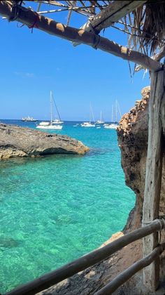 the water is crystal blue and clear with boats in it