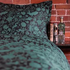 an image of a bedroom setting with brick wall in the background and green bedding