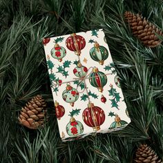 a present wrapped in wrapping paper on top of pine cones