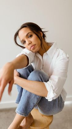 a woman sitting on top of a wooden stool