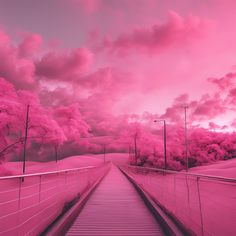 a bridge that has pink trees on both sides and clouds in the sky above it