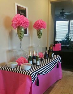 the table is decorated with pink flowers and wine bottles