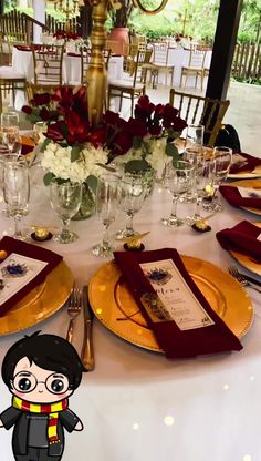 the table is set with gold plates and red napkins, silverware, and flowers