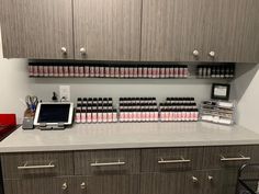 a counter top with many bottles on it and a tablet in front of the counter