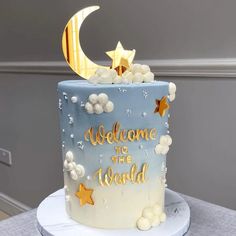 a blue and white cake decorated with stars, moon and the words welcome to the world