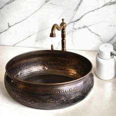 a bathroom sink sitting on top of a counter next to a soap dispenser