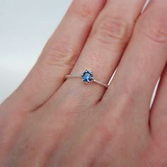 a woman's hand with a blue ring on it