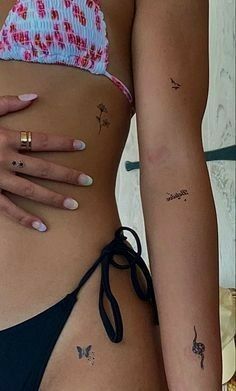 two women with tattoos on their stomachs and one has a small flower tattoo on her left side