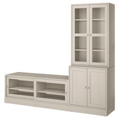 a white entertainment center with glass doors and shelves next to it's own cabinet