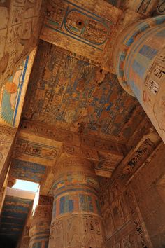 the interior of an ancient egyptian temple with columns and paintings on the ceiling, egypt