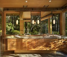 a large bathroom with an outdoor jacuzzi tub in the middle and trees outside