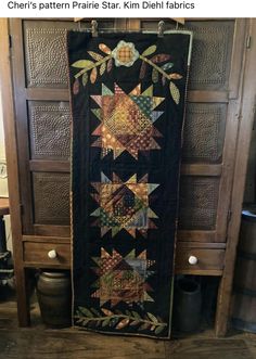 a quilt hanging on the side of a wooden cabinet