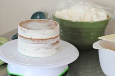 a cake sitting on top of a white plate next to a bowl filled with whipped cream