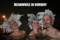 three people in the water with paper hats on their heads and one man wearing a beard