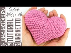 a hand holding a pink crocheted heart in it's left hand, with the words core amigurmi written below