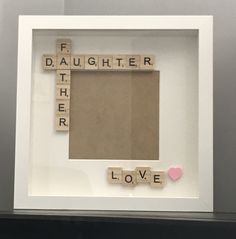 a white frame with scrabble letters and a pink heart