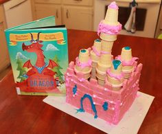 a cake made to look like a castle with pink icing and decorations on it