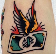 a tattoo on the leg of a person with a bird and money sign in it