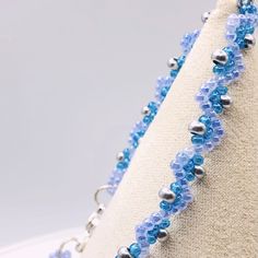 a blue and silver beaded necklace on a mannequin