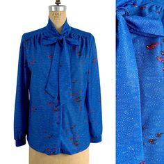 "Vintage now neck sapphire blue blouse with retro boomerang print by Devon. Print has small retro red, purple and black boomerangs and a small white overall pattern like mini comet trails. Front shoulder plackets, full button front. Long cuffed sleeves. Tie neck. SIZE approximately XL, please use the measurements below to determine fit TAG Devon and ILGWU MATERIAL polyester knit with slight stretch CARE machine wash, hang dry MEASUREMENTS (taken flat then doubled) Bust 38\" Waist 39\" Hip 42\" S Blue Fitted Tie Neck Tops, Blue Blouse With Vintage Print For Spring, Vintage Blue Blouse For Fall, Blue Fitted Tie Neck Blouse, Blue Fitted Blouse With Tie Neck, Spring Retro Tie-neck Tops, Spring Retro Tie Neck Tops, Retro Tie Neck Tops For Spring, Retro Blue Blouse For Fall