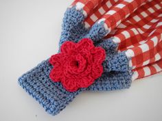 a red and white checkered cloth with a crocheted flower on it's end