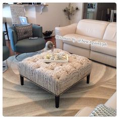 a living room with couches, chairs and a coffee table in the middle of it