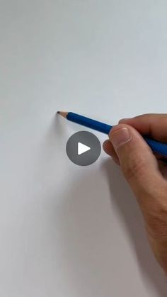 a person holding a pencil in their left hand and writing on paper with the eraser