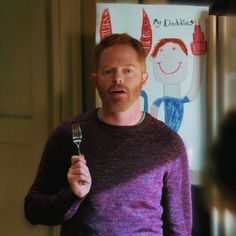 a man holding a fork in front of a poster